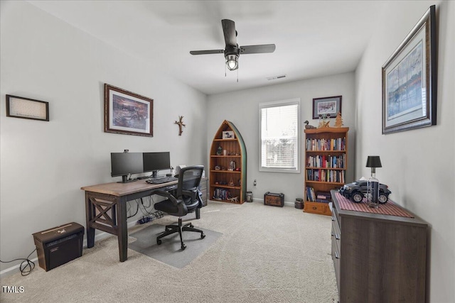 carpeted office space featuring visible vents, baseboards, and ceiling fan