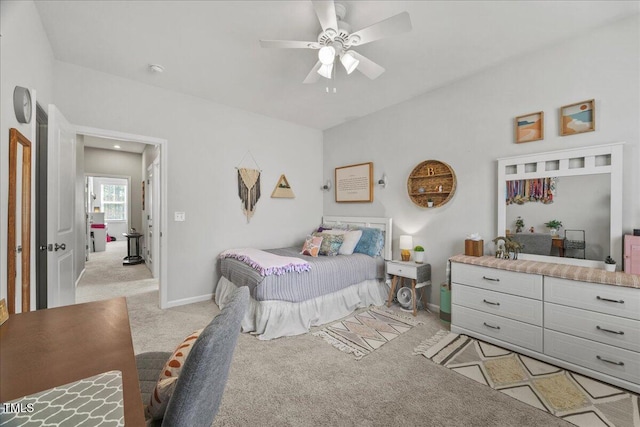 bedroom with light colored carpet, a ceiling fan, and baseboards