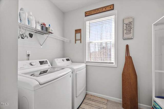 laundry area featuring laundry area, washing machine and dryer, and baseboards