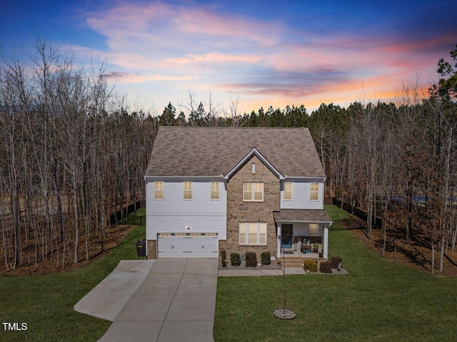 view of front of property featuring a lawn, a garage, and driveway