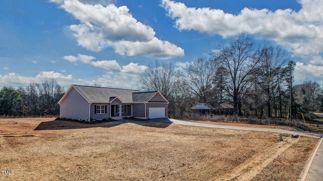 ranch-style home featuring concrete driveway and an attached garage