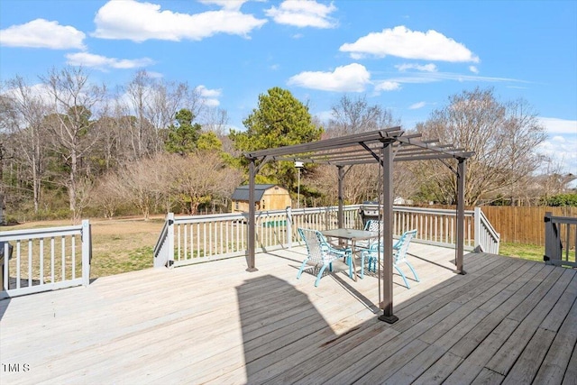 deck with an outbuilding, fence, a storage shed, and a pergola