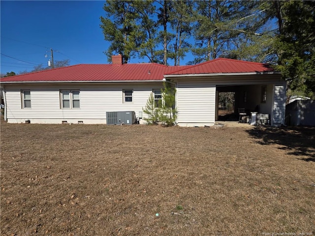 back of property with metal roof, central AC, a yard, crawl space, and a chimney