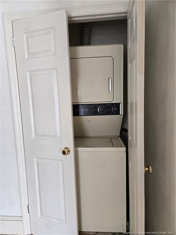 clothes washing area featuring laundry area and stacked washer and clothes dryer