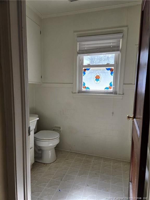 bathroom with toilet, vanity, crown molding, and tile patterned floors