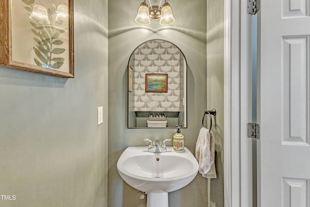 bathroom with an inviting chandelier and a sink