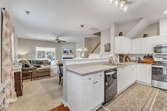 kitchen featuring visible vents, appliances with stainless steel finishes, backsplash, a peninsula, and a sink