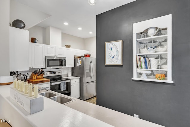 kitchen with stainless steel appliances, white cabinets, a sink, and tasteful backsplash