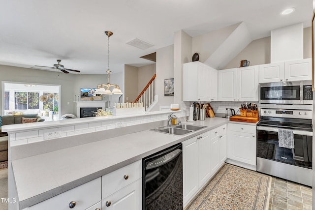 kitchen featuring a fireplace, tasteful backsplash, appliances with stainless steel finishes, open floor plan, and a sink