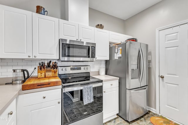 kitchen with white cabinets, appliances with stainless steel finishes, light countertops, and backsplash