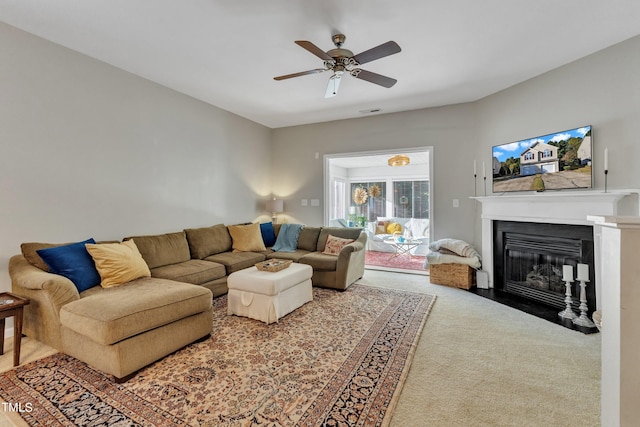 carpeted living area featuring a fireplace with flush hearth and a ceiling fan