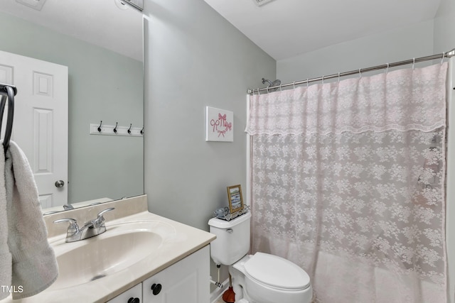 bathroom with curtained shower, vanity, and toilet