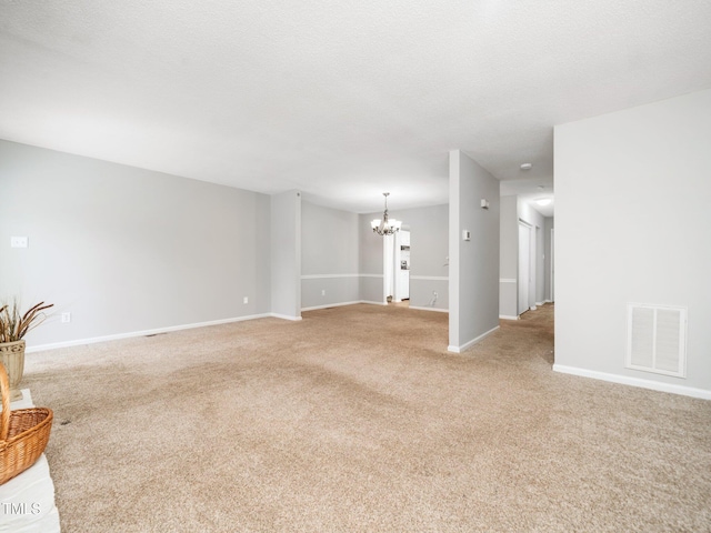 unfurnished living room featuring baseboards, visible vents, a chandelier, and light colored carpet