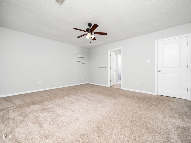 unfurnished room featuring a textured ceiling, ceiling fan, carpet flooring, and baseboards