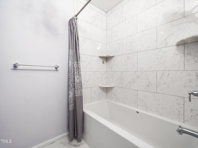 bathroom with shower / tub combo, marble finish floor, and baseboards