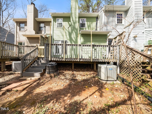 back of property featuring a chimney, a deck, and central AC