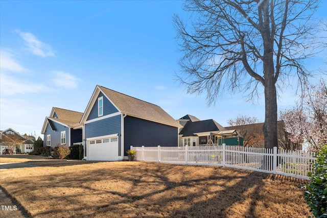 view of front of home featuring a garage, a front lawn, fence, and a residential view