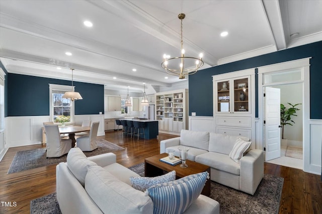 living area featuring dark wood-style floors, beam ceiling, wainscoting, and a decorative wall