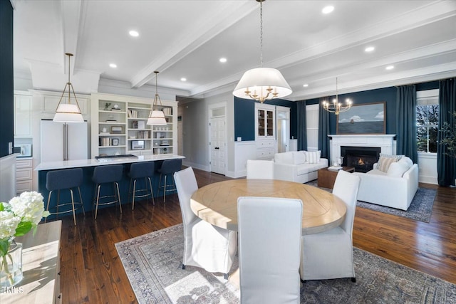 dining space with beam ceiling, dark wood-style flooring, crown molding, recessed lighting, and a warm lit fireplace