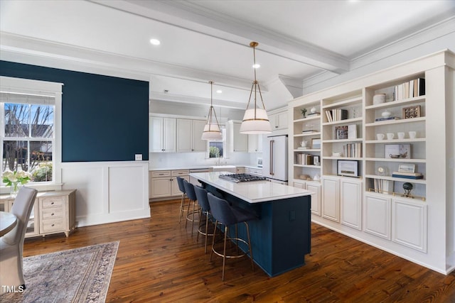 kitchen with stainless steel appliances, beam ceiling, a center island, open shelves, and a kitchen bar