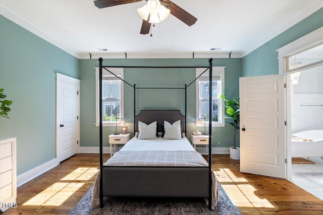 bedroom featuring ornamental molding, wood finished floors, visible vents, and baseboards