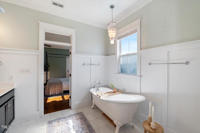 ensuite bathroom with visible vents, a wainscoted wall, a soaking tub, ensuite bathroom, and vanity