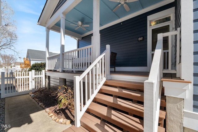 doorway to property with covered porch, ceiling fan, and fence