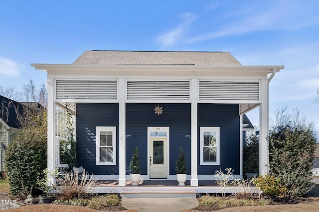 view of front of property with covered porch and roof with shingles