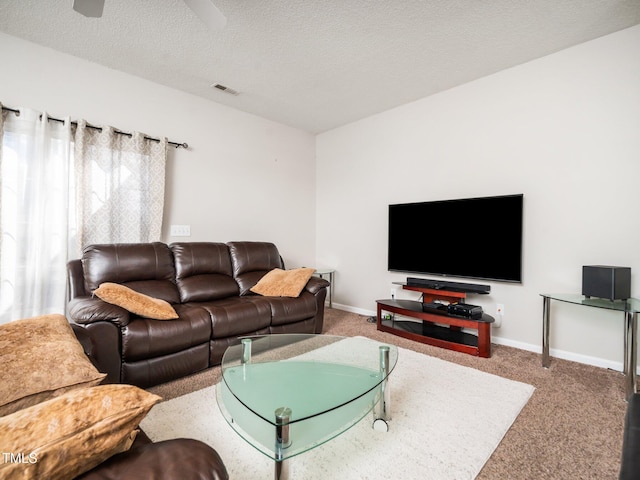 carpeted living room featuring visible vents, baseboards, ceiling fan, and a textured ceiling