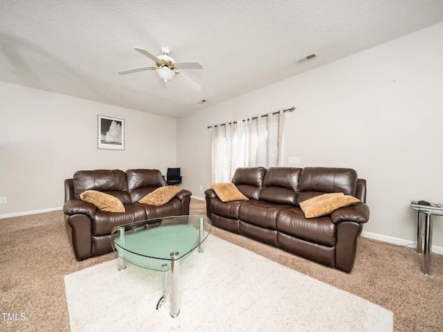 carpeted living room featuring visible vents, ceiling fan, a textured ceiling, and baseboards