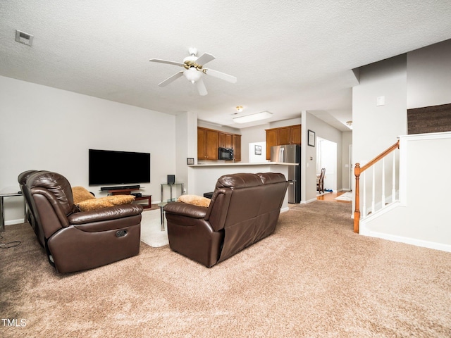 living room featuring light carpet, a textured ceiling, and stairs