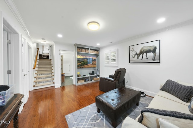 living area featuring stairway, crown molding, and wood finished floors