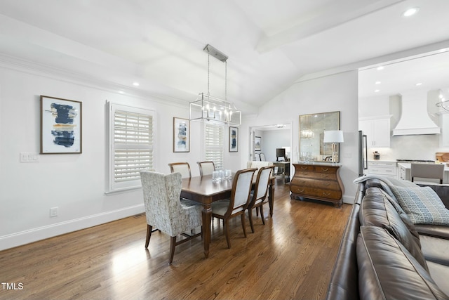 dining room featuring a notable chandelier, baseboards, lofted ceiling, and wood finished floors