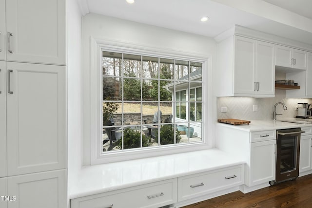 kitchen featuring tasteful backsplash, a sink, wine cooler, white cabinetry, and open shelves