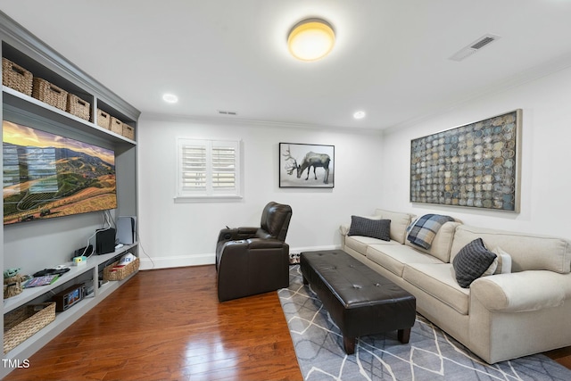 living area with visible vents, baseboards, dark wood-type flooring, and crown molding