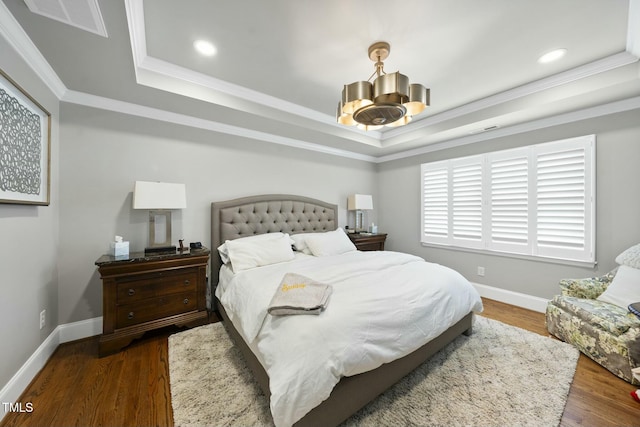 bedroom with a raised ceiling, a notable chandelier, wood finished floors, and baseboards