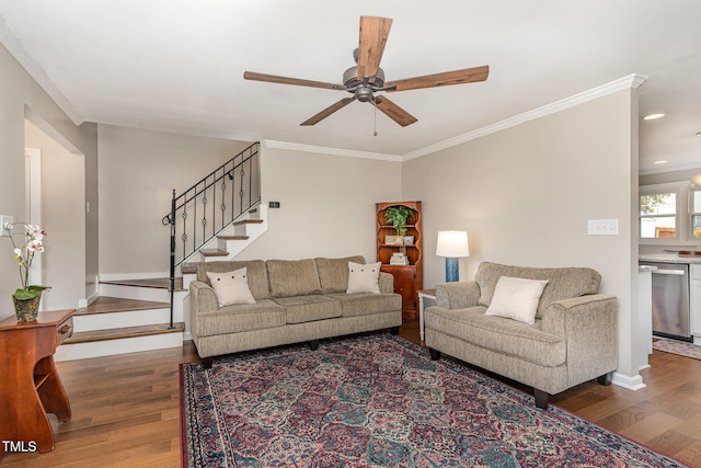 living room with ceiling fan, stairs, ornamental molding, and wood finished floors