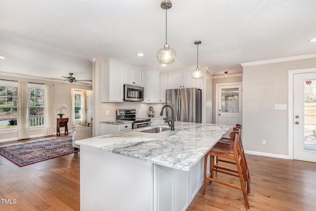 kitchen with stainless steel appliances, dark wood-style flooring, white cabinets, and a sink