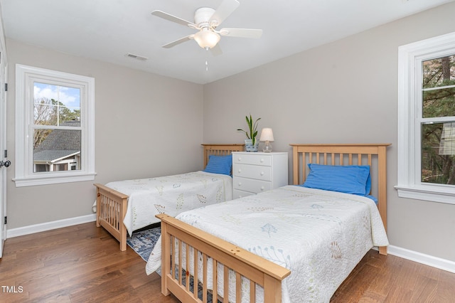 bedroom featuring visible vents, ceiling fan, baseboards, and wood finished floors