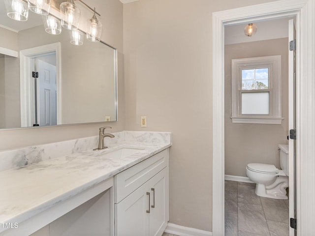 bathroom featuring baseboards, vanity, and toilet