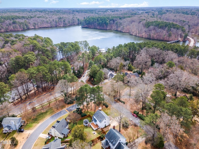 aerial view with a water view and a wooded view