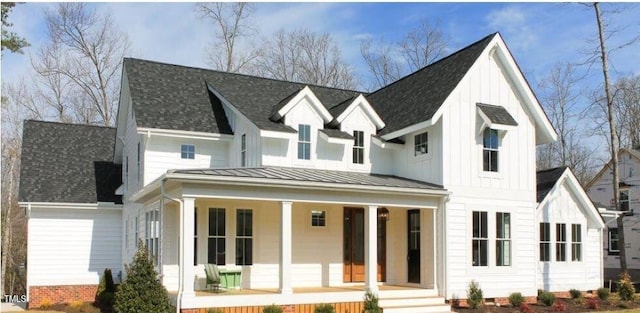 view of front of house with a standing seam roof, metal roof, covered porch, a shingled roof, and board and batten siding