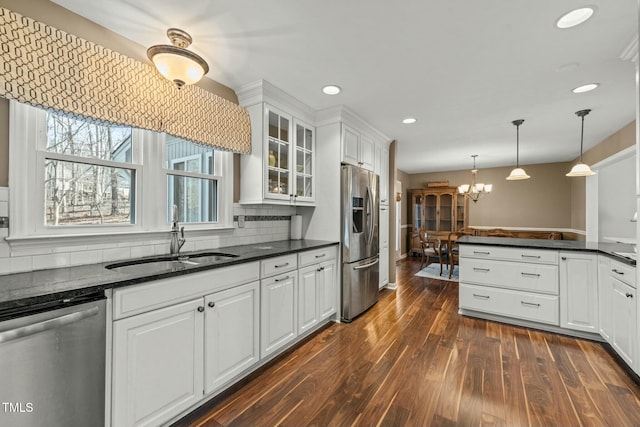 kitchen featuring stainless steel appliances, dark wood-type flooring, a sink, white cabinetry, and glass insert cabinets