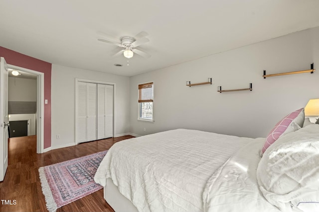 bedroom with ceiling fan, a closet, wood finished floors, and baseboards