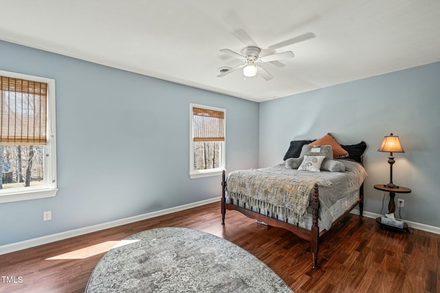 bedroom with a ceiling fan, multiple windows, baseboards, and wood finished floors