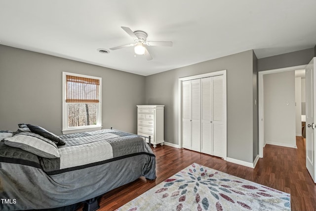 bedroom featuring ceiling fan, wood finished floors, visible vents, baseboards, and a closet