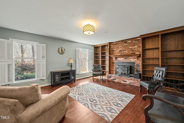 living room with built in shelves, baseboards, and wood finished floors