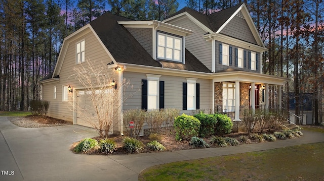 view of front of home with driveway and a shingled roof