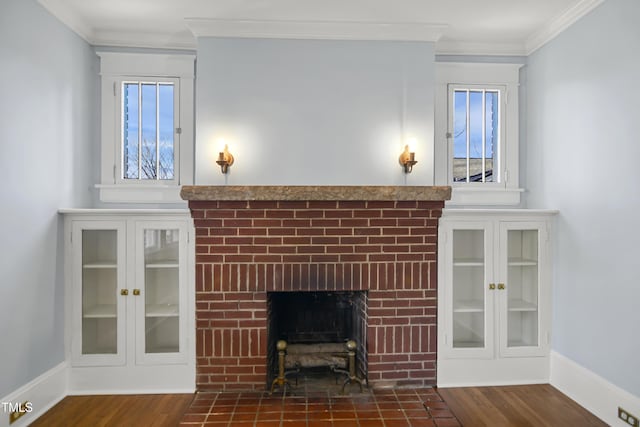 unfurnished living room featuring ornamental molding, a fireplace, baseboards, and wood finished floors