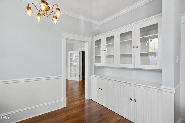 corridor featuring ornamental molding, dark wood-style flooring, and a notable chandelier